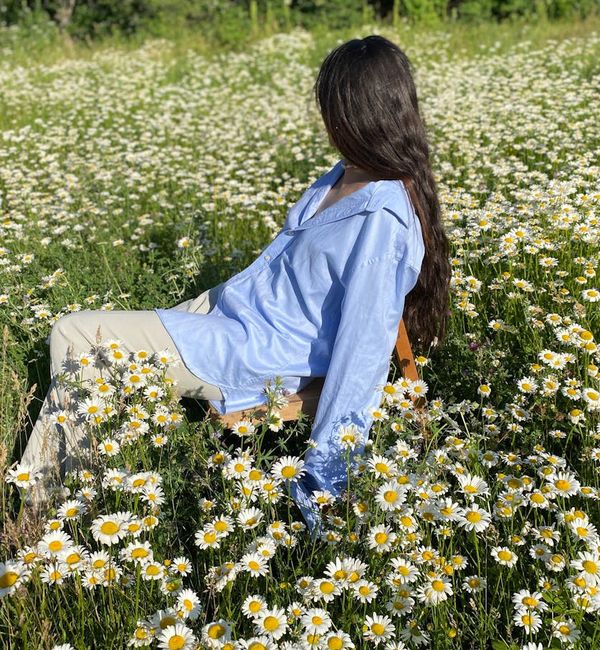 Person stretching gently outdoors with a serene natural background.