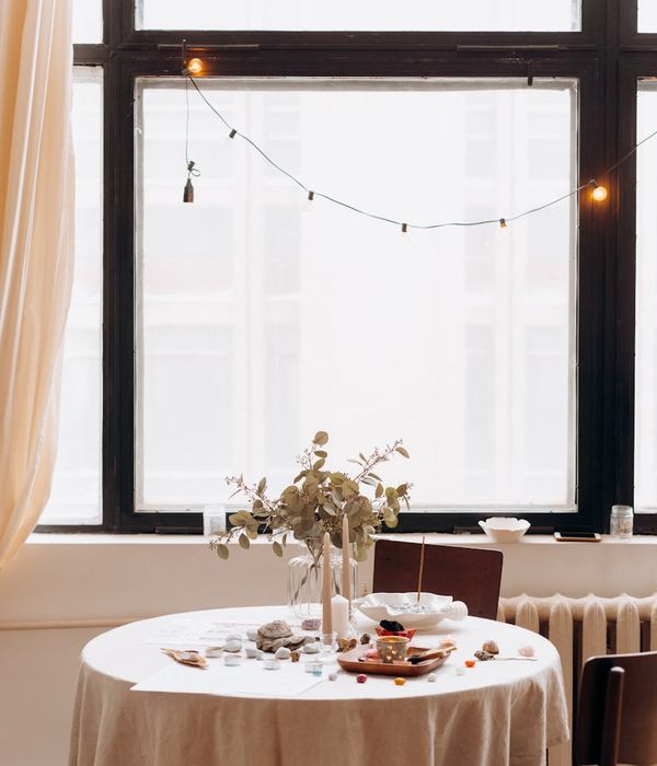Woman in a peaceful yoga pose in a bright, minimalist room.